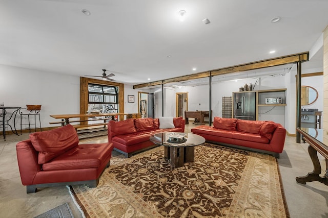 living room with a barn door and ceiling fan