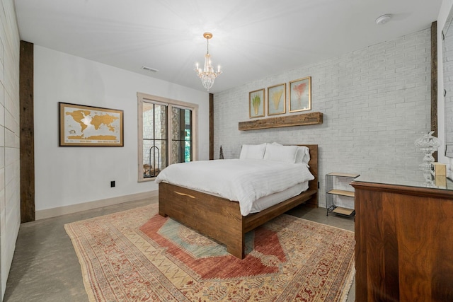 bedroom featuring a chandelier and brick wall