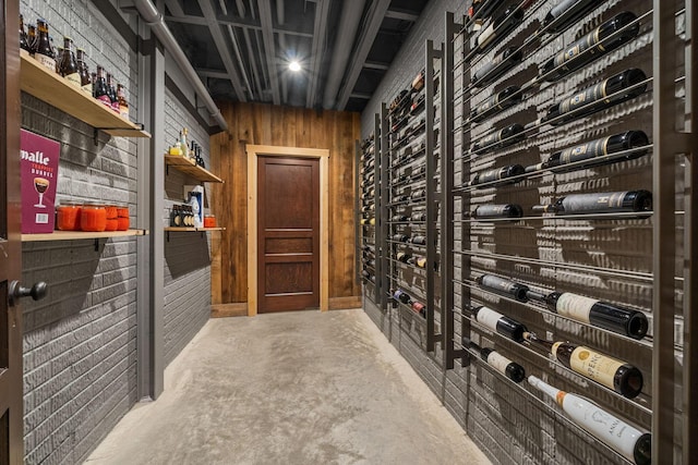 wine room featuring wooden walls and concrete flooring