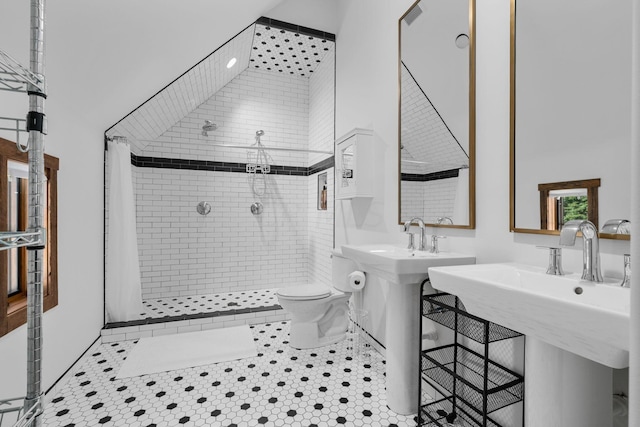 bathroom with a tile shower, tile patterned flooring, and toilet