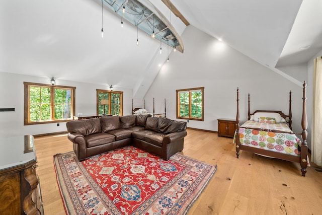 living room with vaulted ceiling with beams, ceiling fan, light hardwood / wood-style floors, and plenty of natural light