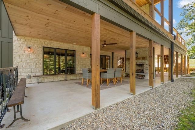 view of patio / terrace with ceiling fan and an outdoor stone fireplace