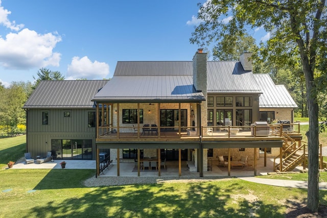 back of house with a wooden deck, a patio area, and a lawn