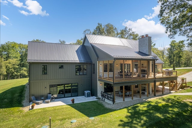 rear view of property featuring a deck, a patio, a yard, and central air condition unit