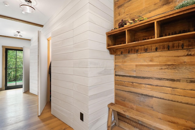 mudroom with wood walls and light hardwood / wood-style floors