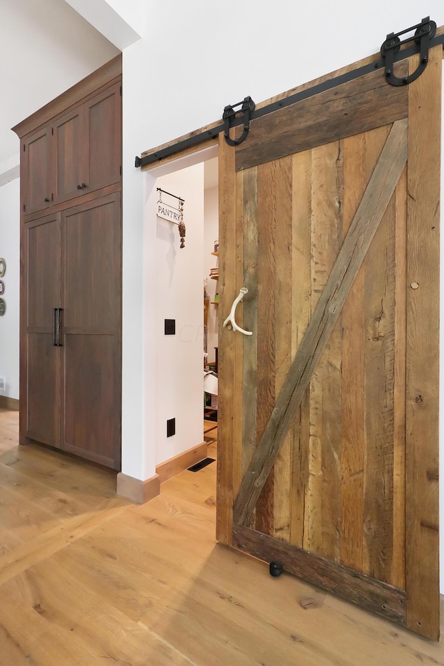 interior space with a barn door and hardwood / wood-style flooring