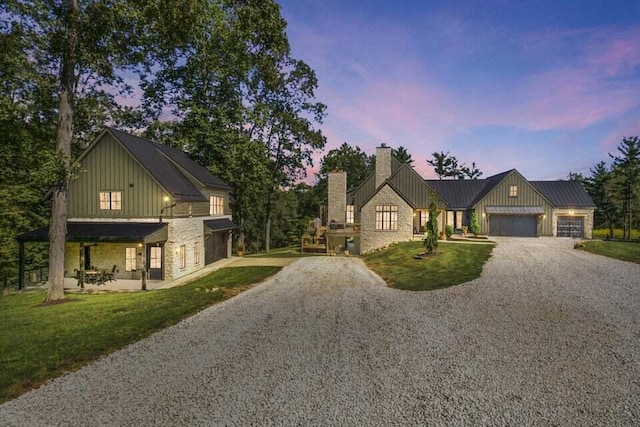 modern inspired farmhouse featuring a garage and a yard