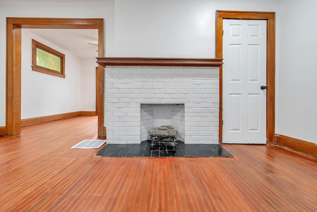 unfurnished living room featuring a fireplace and hardwood / wood-style flooring