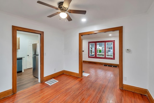 empty room with hardwood / wood-style floors and ceiling fan