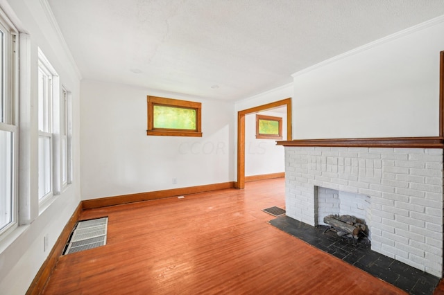 unfurnished living room featuring a fireplace, a textured ceiling, light hardwood / wood-style flooring, and crown molding