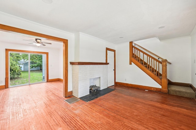 unfurnished living room with a fireplace, wood-type flooring, ceiling fan, and crown molding