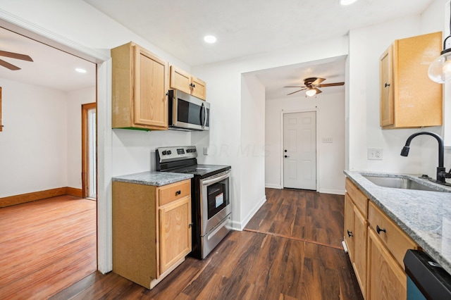 kitchen with light stone countertops, ceiling fan, sink, stainless steel appliances, and dark hardwood / wood-style flooring