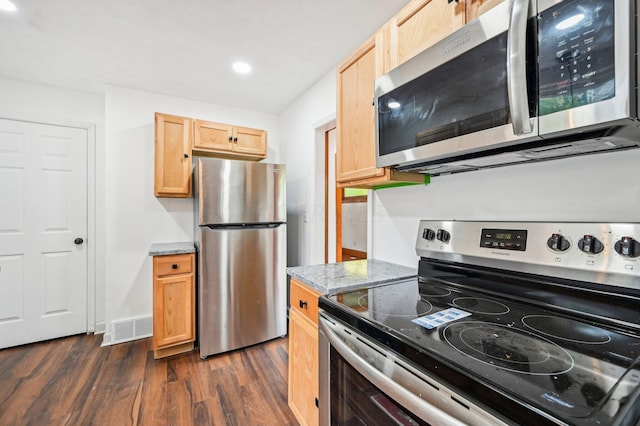 kitchen with appliances with stainless steel finishes, dark hardwood / wood-style flooring, light stone counters, and light brown cabinets