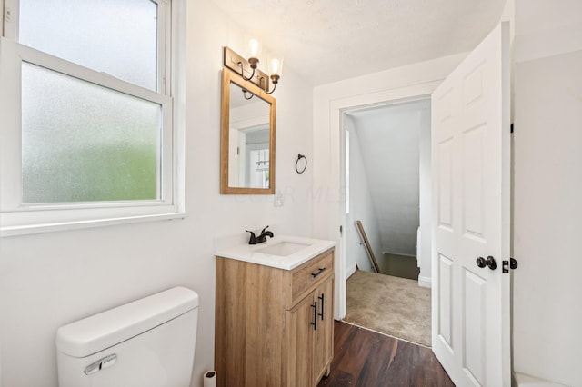 bathroom featuring toilet, vanity, a healthy amount of sunlight, and hardwood / wood-style flooring