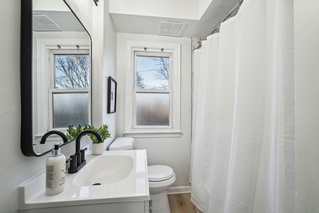 bathroom with hardwood / wood-style floors, vanity, and toilet