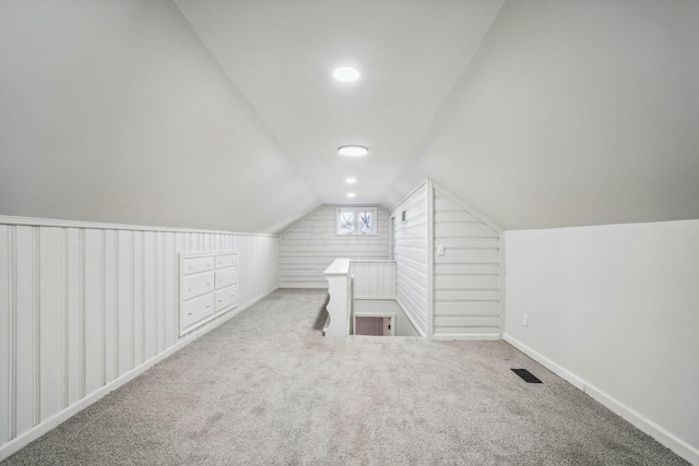 bonus room with light carpet and vaulted ceiling