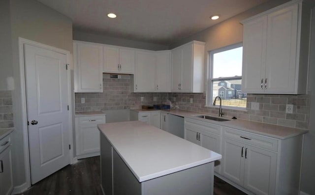 kitchen with backsplash, sink, a center island, dark hardwood / wood-style floors, and white cabinetry