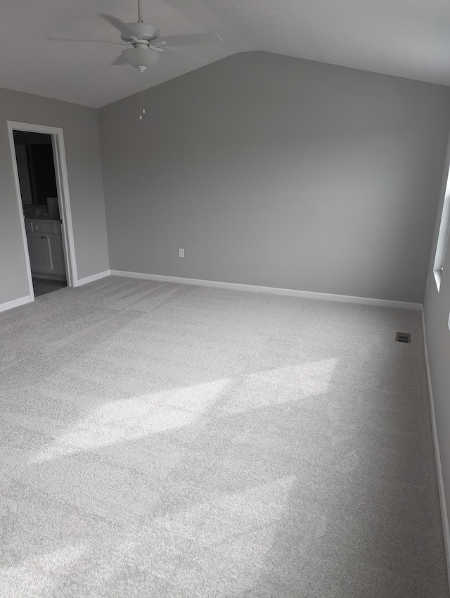 carpeted spare room with ceiling fan and lofted ceiling