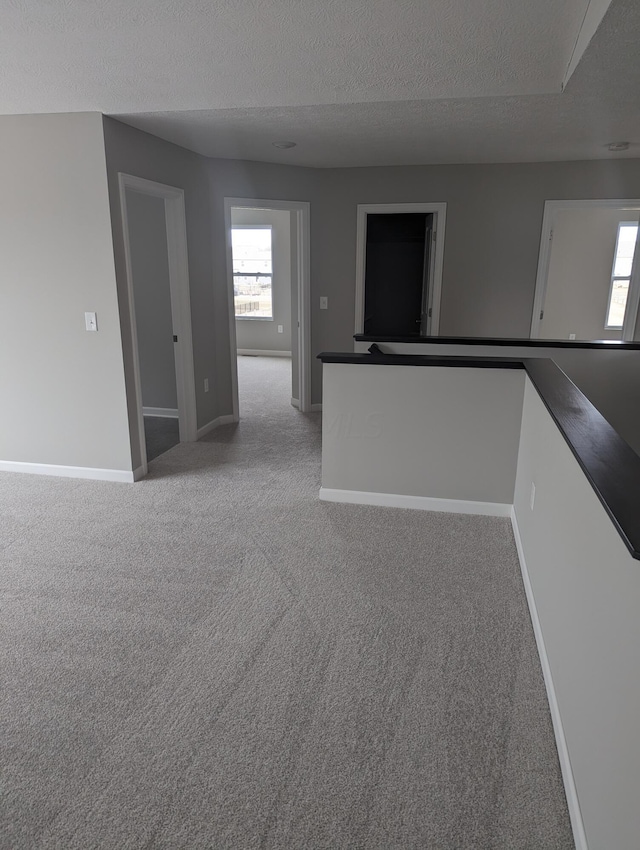 spare room with light carpet and a textured ceiling