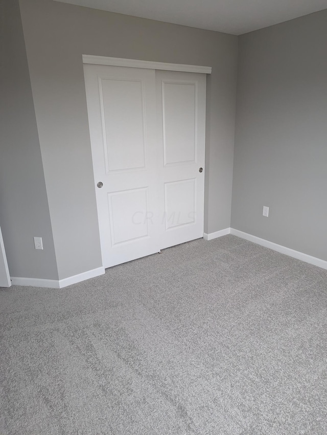 unfurnished bedroom with carpet floors and a closet