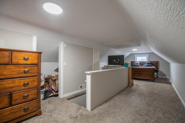 carpeted bedroom featuring a textured ceiling and lofted ceiling