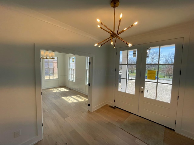 doorway featuring a chandelier, french doors, and light hardwood / wood-style floors