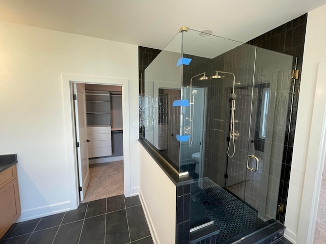 bathroom featuring tile patterned floors, toilet, vanity, and walk in shower