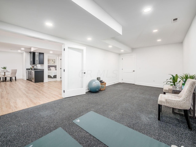 exercise area with sink and wood-type flooring