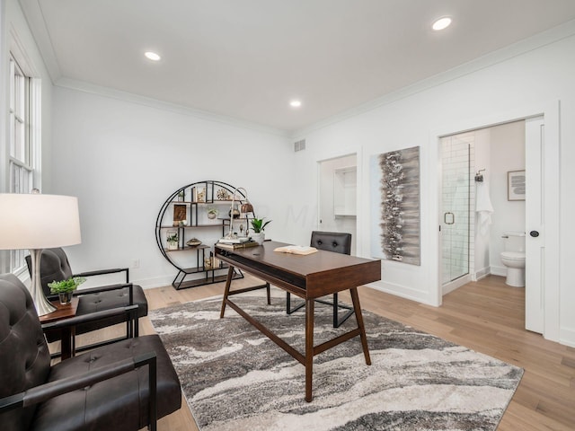 home office featuring light wood-type flooring and crown molding