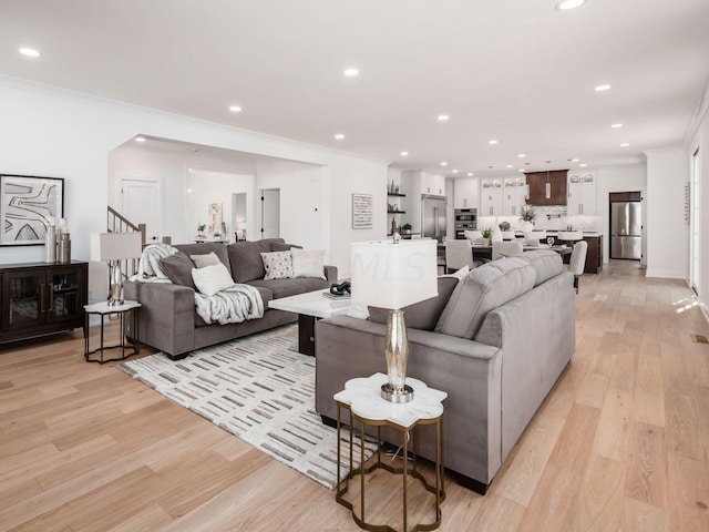 living room featuring crown molding and light hardwood / wood-style floors