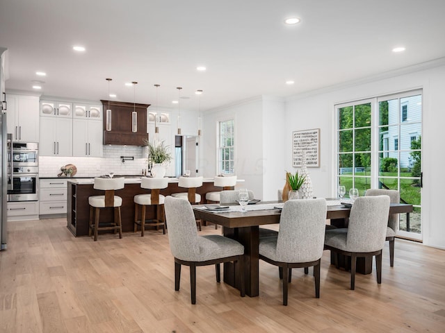 dining room featuring light hardwood / wood-style flooring and crown molding