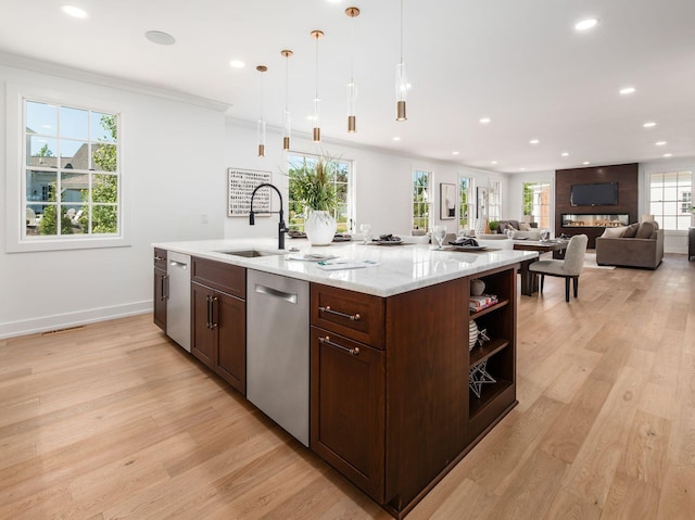 kitchen with a wealth of natural light, dishwasher, decorative light fixtures, and light wood-type flooring