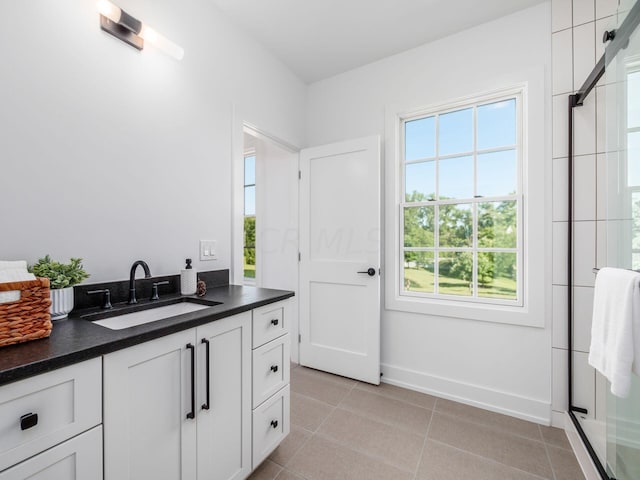 bathroom with tile patterned floors, vanity, and walk in shower