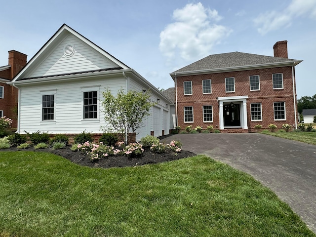 colonial home with a garage and a front yard