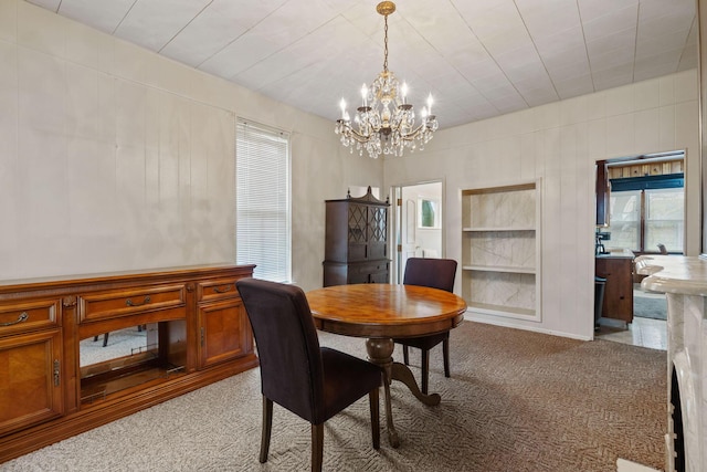 carpeted dining area featuring a notable chandelier