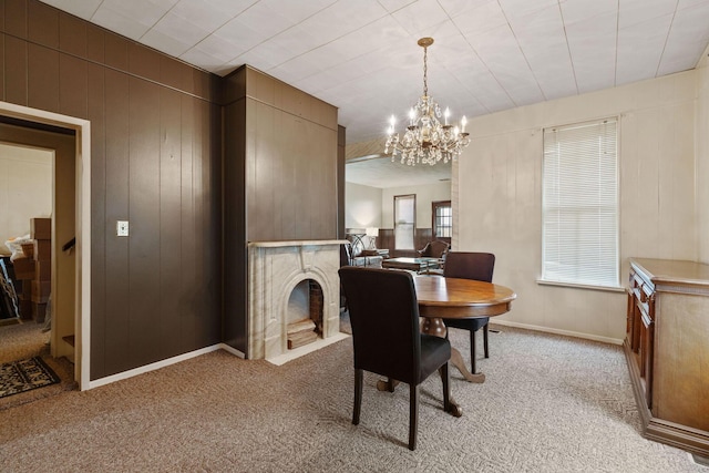 carpeted dining area with wooden walls and an inviting chandelier