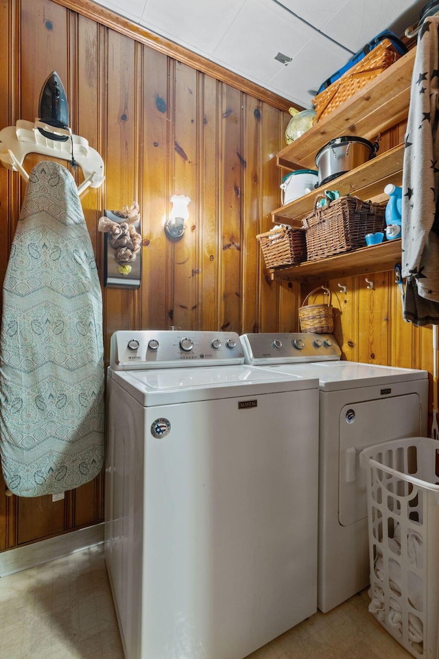 washroom featuring washer and clothes dryer and wooden walls