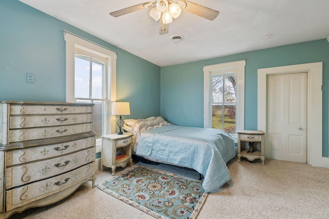 carpeted bedroom featuring ceiling fan and multiple windows