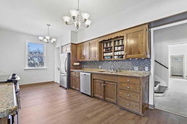 kitchen with sink, dark hardwood / wood-style floors, appliances with stainless steel finishes, decorative light fixtures, and a chandelier