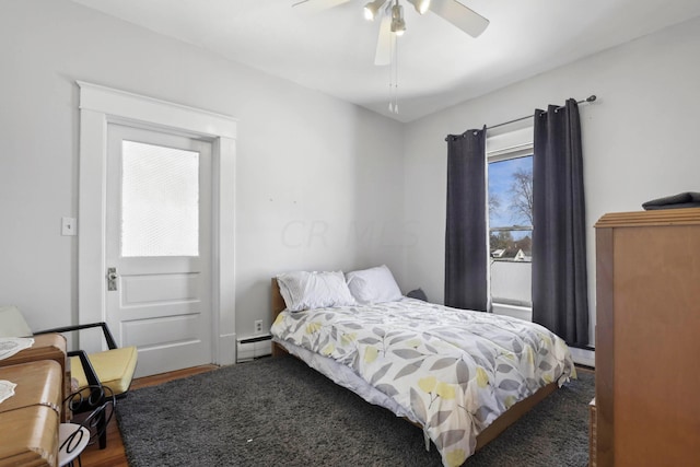 bedroom featuring dark hardwood / wood-style flooring, a baseboard radiator, and ceiling fan