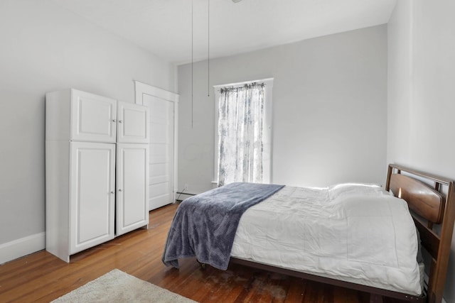 bedroom with wood-type flooring and a baseboard radiator