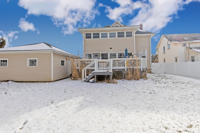 snow covered rear of property featuring a wooden deck