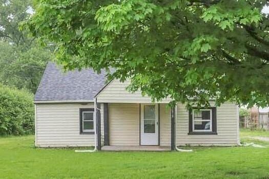 back of property featuring a lawn