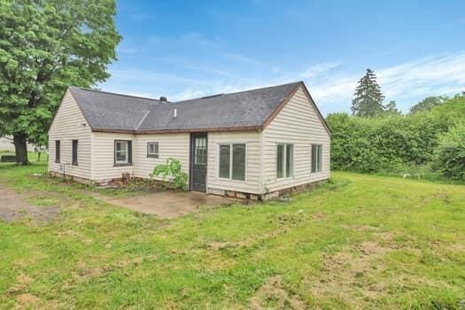 back of house featuring a patio and a lawn