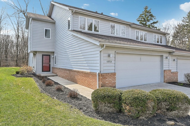 view of front of house with a garage, concrete driveway, brick siding, and a front lawn