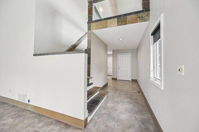 entryway with recessed lighting, visible vents, stairway, concrete flooring, and baseboards