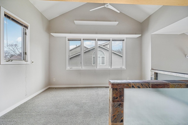 interior space with a ceiling fan, lofted ceiling, carpet flooring, and baseboards