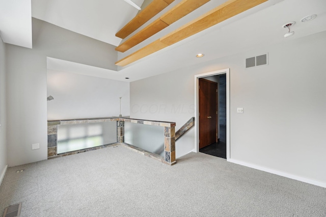 carpeted spare room featuring visible vents and baseboards