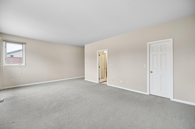 unfurnished room with carpet floors, visible vents, and baseboards