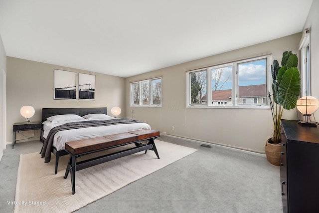 bedroom with baseboards and light colored carpet